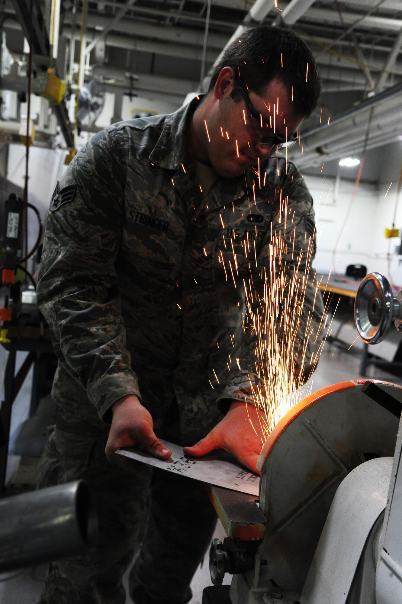 U.S. Air Force Senior Airman Spencer Stringer, 495th Fighter Group structural maintenance technician, shaves metal at Whiteman Air Force Base, Mo., Sept. 15, 2015. Parts must be shaved in order to fit properly on an aircraft. (U.S. Air Force photo by Senior Airman Keenan Berry/Released)





