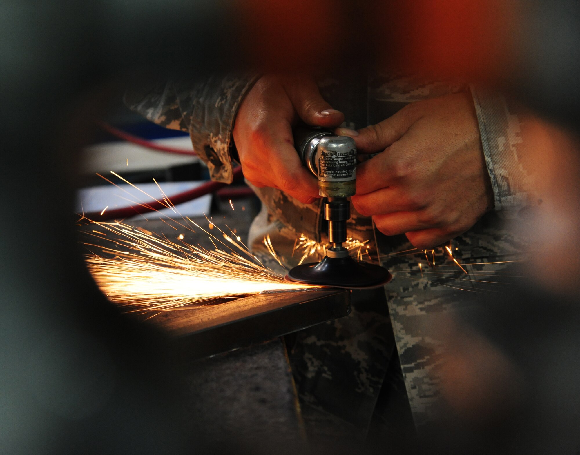 U.S. Air Force Staff Sgt. AJ Long, grinds a door frame at Whiteman Air Force Base, Mo., Sept. 15, 2015. This process is done to clean up wield marks from the wielding procedure. (U.S. Air Force photo by Senior Airman Keenan Berry/Released)



