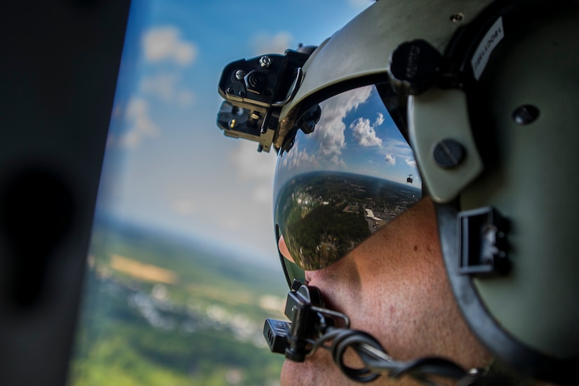 Tech. Sgt. Justin Cole, 1st Helicopter Squadron flight engineer, looks back at a UH-1N Iroquois during a flyover for the 2015 Joint Base Andrews Air Show, Sept. 19. The 1 HS performed a fly-by for the crowd during the event. (U.S. Air Force photo/Airman 1st Class Ryan J. Sonnier/Released)