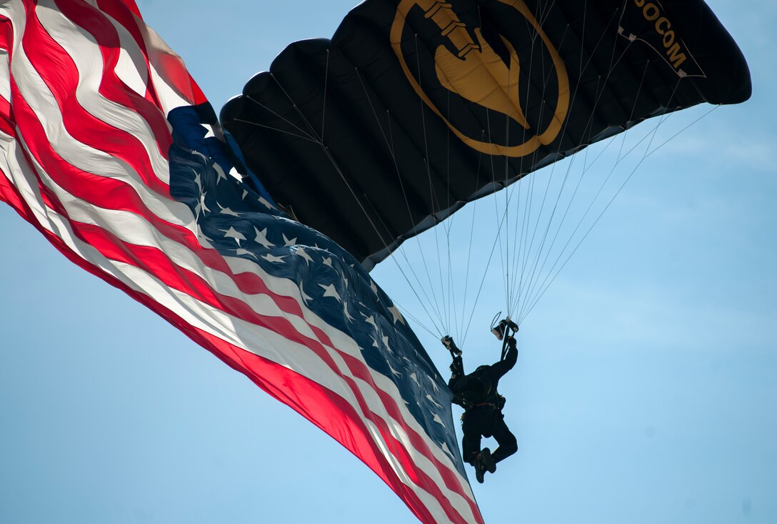 A member of the para-commandos jump team parachutes with an American flag during the 2015 Joint Base Andrews Air Show, Sept. 19. The U.S. Air Force holds air shows to inspire patriotism and demonstrate air superiority to the local community. (U.S Air Force photo by Airman 1st Class Philip Bryant/Released)
