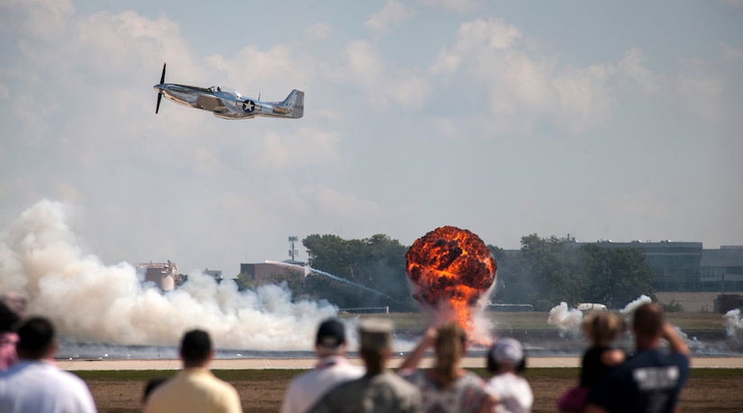 A P-51 Mustang flies over the Joint Base Andrews flightline during the 2015 Air Show as part of the “Warbirds” performance on Sept. 19. The performance included coordinated pyrotechnics and period style low passes. (U.S Air Force photo by Airman 1st Class Philip Bryant/Released)