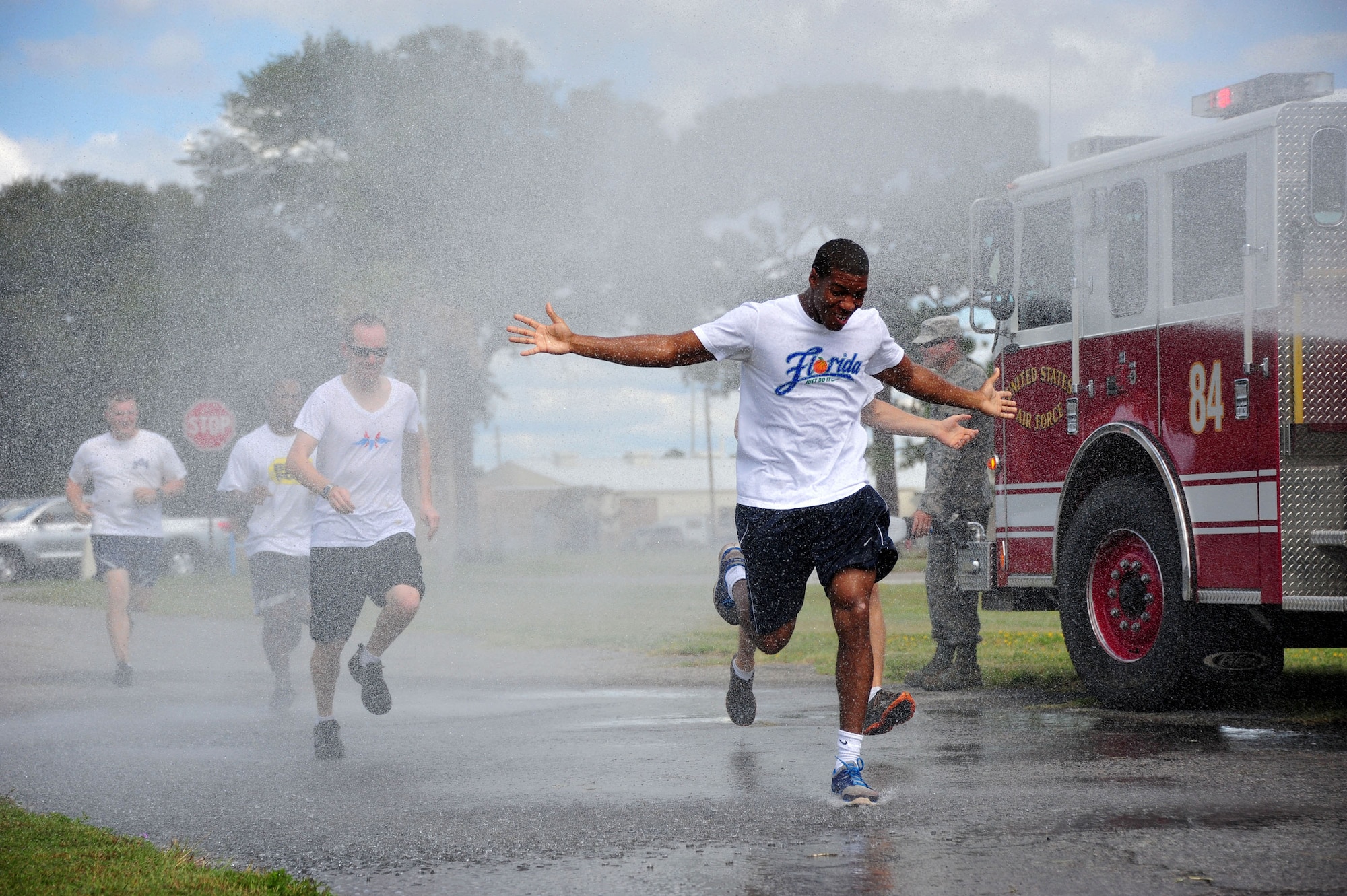 Runners get soaked with hoses from an Eglin Air Force Base, Fla., fire truck at the start of the Combined Federal Campaign Color Fun Run Sept. 17. The three-mile run is the first of several events promoting the campaign now through Dec. 3. (U.S. Air Force Photo/Jasmine Porterfield)