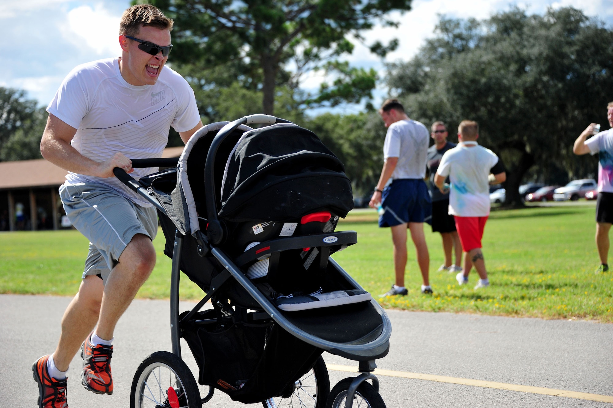 2nd Lt. Andrew Starita, Air Force Lifecycle Management Center, sprints toward the finish line pushing his daughter in tow during the Combined Federal Campaign Color Fun Run Sept. 17 at Eglin Air Force Base, Fla. Because there were no children runners, Starita’s daughter, Leah, was considered the first child to complete the three-mile run at 27 minutes and 54 seconds. Medals were awarded for the first male, female and child runners. The run is the first of several events promoting the campaign now through Dec. 3. (U.S. Air Force Photo/Jasmine Porterfield)