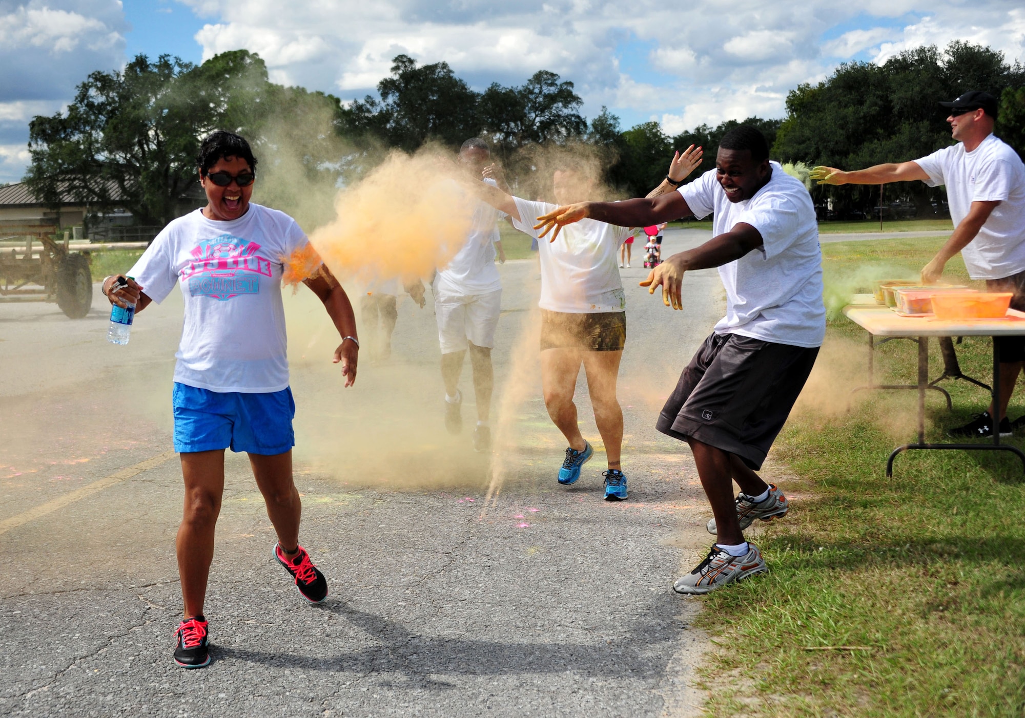 Volunteers shower runners with chalk during the Combined Federal Campaign Color Fun Run Sept. 17 at Eglin Air Force Base, Fla. The three-mile run is the first of several events promoting the campaign now through Dec. 3. (U.S. Air Force Photo/Jasmine Porterfield)