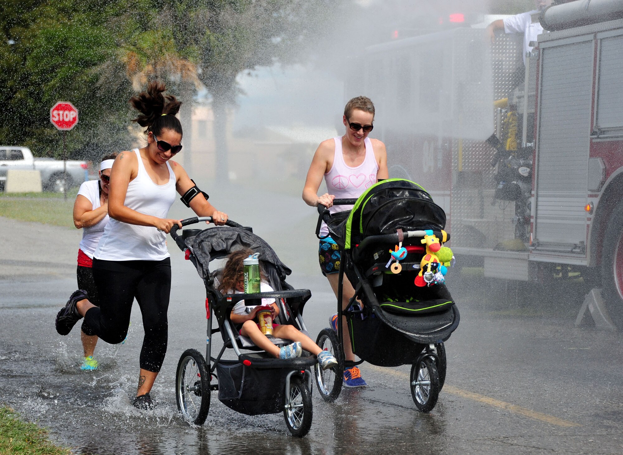 Runners get soaked with hoses from an Eglin Air Force Base, Fla., fire truck at the start of the Combined Federal Campaign Color Fun Run Sept. 17. The three-mile run is the first of several events promoting the campaign now through Dec. 3. (U.S. Air Force Photo/Jasmine Porterfield)