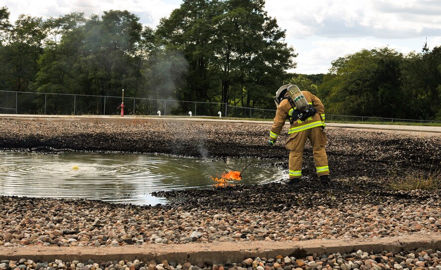 U.S. Air Force Master Sgt. Bart S. Ridings, fire protection specialist with the 182nd Civil Engineer Squadron, Illinois Air National Guard, ignites a pool of jet fuel during a controlled-burn demonstration at Wingman and Family Day at the 182nd Airlift Wing, Peoria, Ill., Sept. 12, 2015. The event was organized to promote resiliency in Airmen and their friends and family. (U.S. Air National Guard photo by Staff Sgt. Lealan Buehrer/Released)