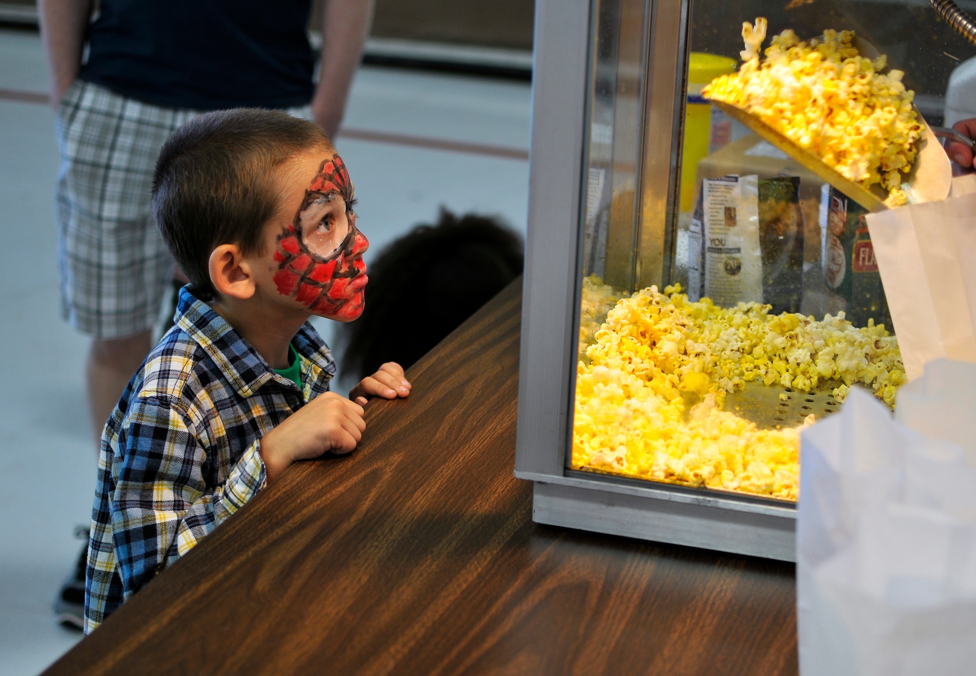 Timothy, son of a 182nd Airlift Wing technical sergeant, watches his bag of popcorn get filled during Wingman and Family Day at the 182nd Airlift Wing, Peoria, Ill., Sept. 12, 2015. The event was organized to promote resiliency in Airmen and their friends and family. (U.S. Air National Guard photo by Staff Sgt. Lealan Buehrer/Released)