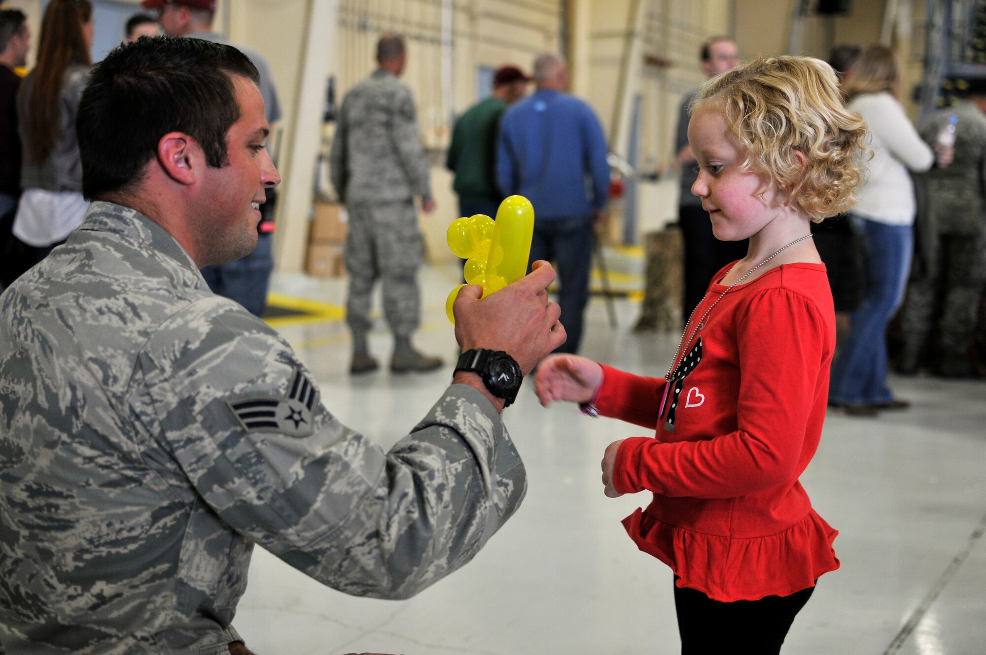 U.S. Air Force Senior Airman Lance A. Liggett, tactical air control party specialist with the 169th Air Support Operations Squadron, Illinois Air National Guard, makes Mallory an animal balloon during Wingman and Family Day at the 182nd Airlift Wing, Peoria, Ill., Sept. 12, 2015. The event was organized to promote resiliency in Airmen and their friends and family. (U.S. Air National Guard photo by Staff Sgt. Lealan Buehrer/Released)