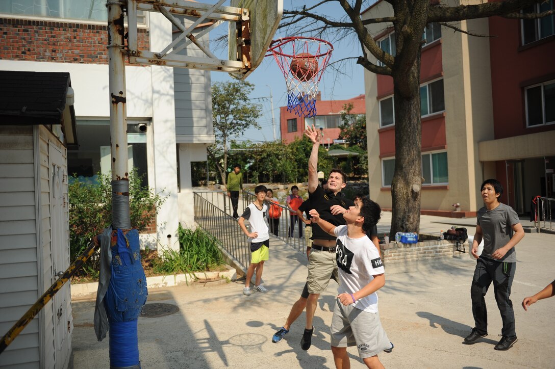 Airmen assigned to the 80th Fighter Squadron, 8th Fighter Wing, Kunsan Air Base, Republic of Korea, play basketball with children at a Gunsan City welfare facility Sept. 19, 2015. Approximately 20 volunteers played soccer, basketball and gonggi with elementary, middle and high school students. Organizations from the 8th FW regularly volunteer time to enhance relationships with the local community and make the wing better. (U.S. Air Force photo by Master Sgt. David Miller)