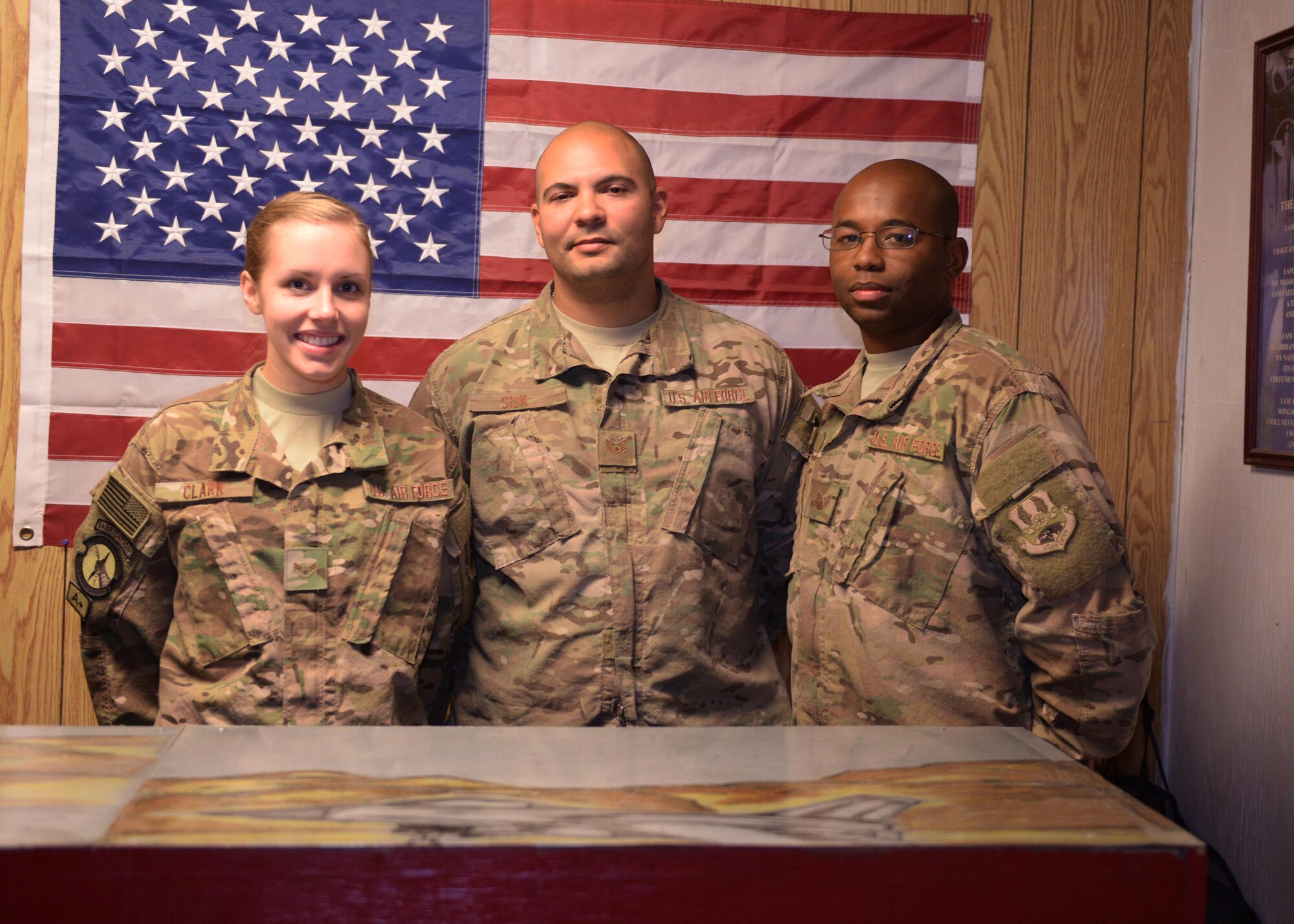 From left to right, U.S. Air Force Airman 1st Class Samantha Clark, Staff Sgt. Douglas Sisk and Tech. Sgt. Isaac Jack, Attic East volunteers, pose for a photo during the grand opening of the new attic east facility Sept. 21, 2015, at Bagram Airfield, Afghanistan. Attic East is a facility that offers donated serviceable uniforms that are in good condition, as well as gear and other items to Service members of all branches free of charge. (U.S. Air Force photo by Senior Airman Cierra Presentado/Released)