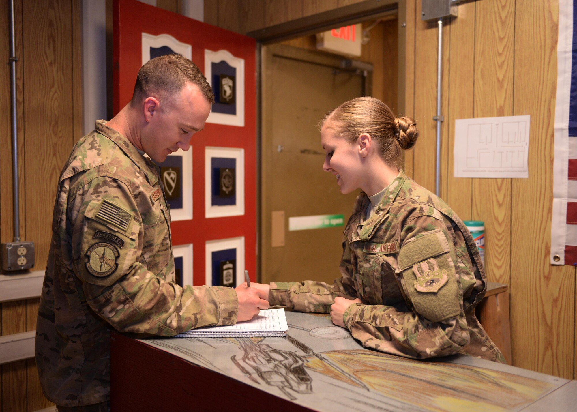 U.S. Airman 1st Class Samantha Clark, 455th Expeditionary Maintenance Squadron non-destructive inspection journeyman, signs a customer into the new Attic East facility Sept. 21, 2015, at Bagram Airfield, Afghanistan. Attic East is a facility that offers donated serviceable uniforms that are in good condition, as well as gear and other items to Service members of all branches free of charge. (U.S. Air Force photo by Senior Airman Cierra Presentado/Released)