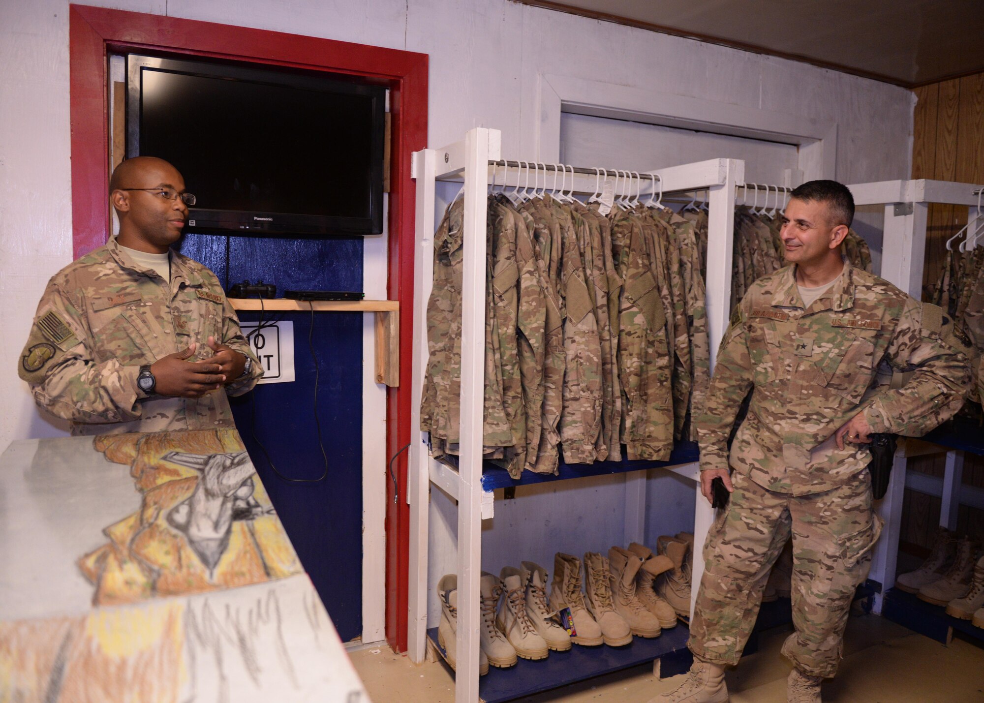 U.S. Air Force Tech. Sgt. Isaac Jack, left, 455th Expeditionary Maintenance Squadron aircrew egress section chief, informs Brig. Gen. David Julazadeh, 455th AEW commander, on the new Attic East facility Sept. 21, 2015, at Bagram Airfield, Afghanistan. Attic East is a facility that offers donated serviceable uniforms that are in good condition, as well as gear and other items to Service members of all branches free of charge. (U.S. Air Force photo by Senior Airman Cierra Presentado/Released)