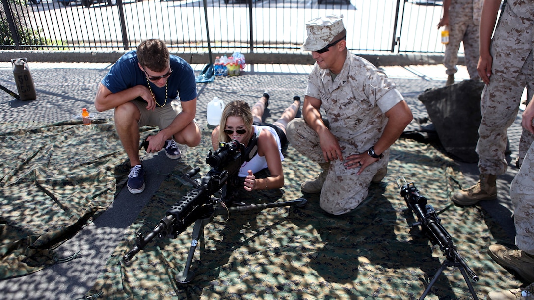 Lance Cpl. Matthew Ritter, a heavy equipment operator with Bulk Fuel Company, 7th Engineer Support Battalion, shows a couple a weapons system during San Diego Fleet Week 2015 at Naval Base Coronado, Calif., Sept. 20, 2015. Thirty-seven Marines from 7th ESB presented static displays during the event to demonstrate the quality of military assets to the citizens of San Diego.