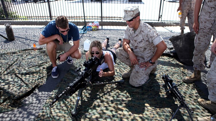 Lance Cpl. Matthew Ritter, a heavy equipment operator with Bulk Fuel Company, 7th Engineer Support Battalion, shows a couple a weapons system during San Diego Fleet Week 2015 at Naval Base Coronado, Calif., Sept. 20, 2015. Thirty-seven Marines from 7th ESB presented static displays during the event to demonstrate the quality of military assets to the citizens of San Diego.