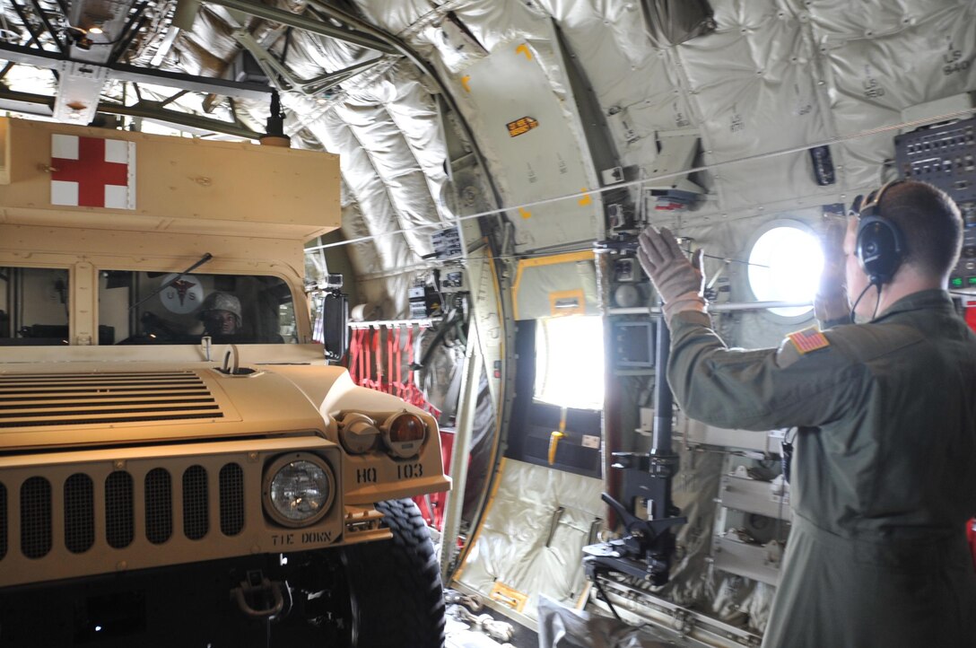 Army Spc. Clarence Jones, a communications specialist in the 890th Engineering Battalion, is directed out of a C-130J aircraft by Senior Airman Tony Distefano, a loadmaster in the 815th Airlift Squadron.  The Air Force Reserve, the Air National Guard and the Army National Guard teamed up for a joint training scenario called Joint Conquest here and at the Gulfport Combat Readiness Training Center, Mississippi Sept. 11-13.