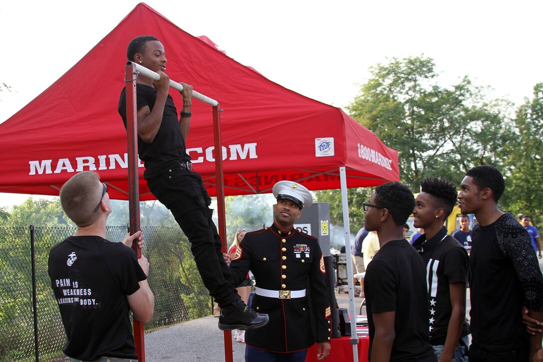 Quaris Gardner, a student at Walnut Hills High School, performs pull-ups during the Marine Corps Pull-Up Challenge at Walnut Hills High School, Aug. 28, 2015.The Walnut Hills Eagles took on the Woodward Bulldogs during the U.S. Marines Battle of the Grid Iron Tour and took home the first Ohio victory of the season with a score of 23-0. (U.S. Marine Corps photo by Sgt. Jennifer Pirante/Released)