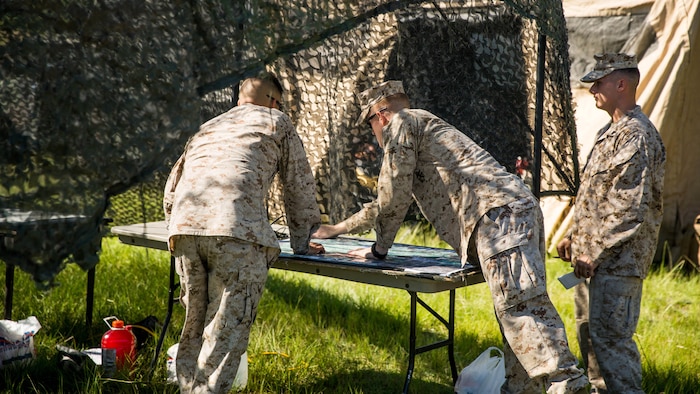 Marines with 10th Marine Regiment, 2nd Marine Division, look over a map of the surrounding area during Operation Firestorm, and exercise to prepare the unit for their upcoming exercise, Rolling Thunder, at Camp Lejeune, N.C., Aug. 15, 2015. The operation is a week-long field operation and is designed to ensure that communication and logistics capabilities are up to par before pushing out to Fort Bragg for Rolling Thunder.