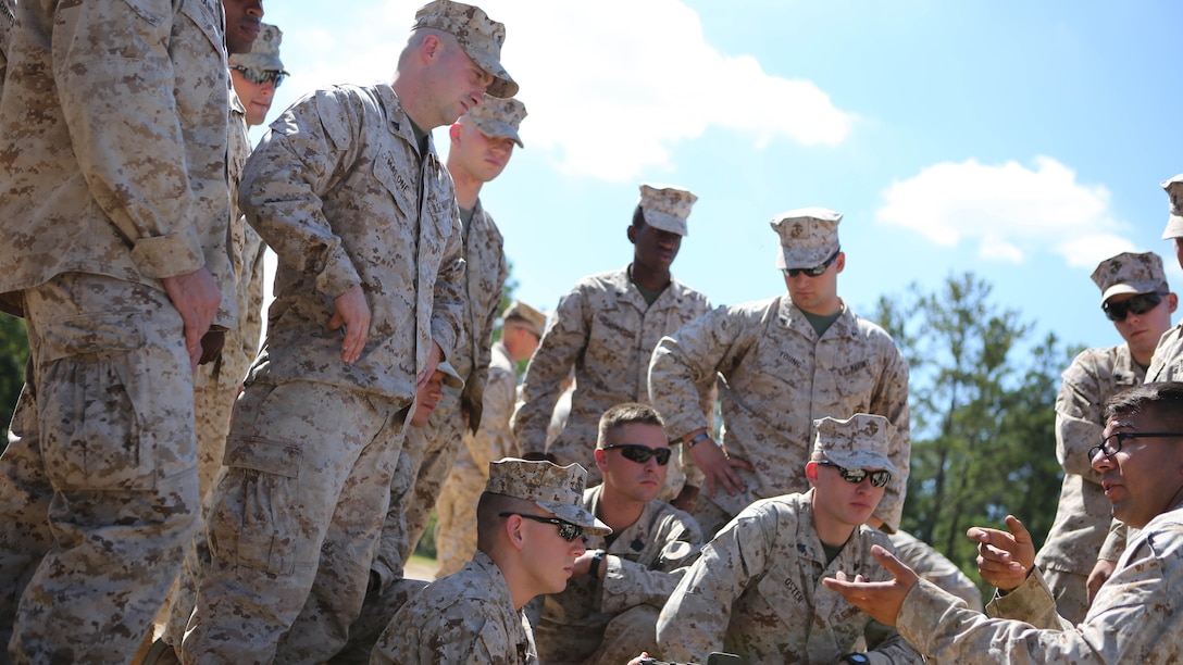 Marines from Battery M, 3rd Battalion, 14th Marine Regiment, 4th Marine Division gather together as a class is given covering the fundamentals, functions and safety procedures of crew-served weapons at Pelham Range in Anniston, Ala., on Sept. 19, 2015. The Marines applied all of their knowledge and increased their proficiency in firing the M249 SAW, the M240 and the M250.