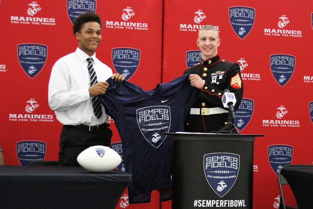 Sean Mahone, high school senior and cornerback for the Lakota West High School Firebirds, receives his Semper Fidelis All-American Bowl selection jersey during a pre-game meal Sept. 18, 2015. The Semper Fidelis Football Program focuses on mentoring exceptional youth athletes and future leaders by collectively celebrating academic excellence, proven physical fitness and quality of character. It also serves as an extension of the Marine Corps focus on developing quality citizens and reinforcing the value of public service. (U.S. Marine Corps photo by Sgt. Jennifer Pirante/Released)