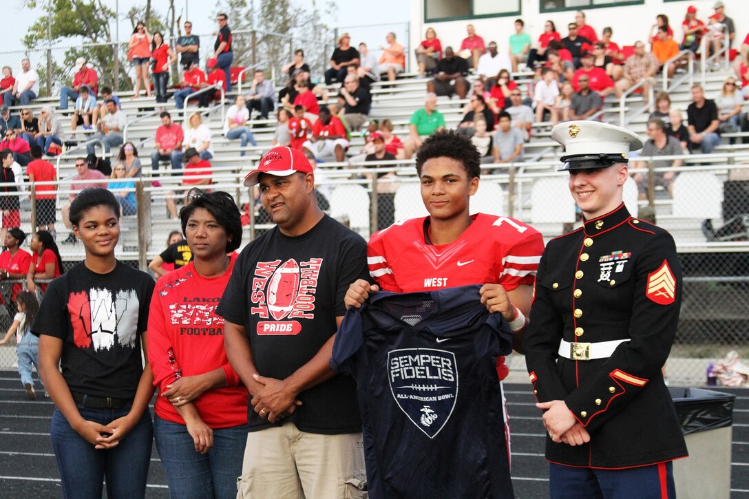 Sean Mahone, high school senior and cornerback for the Lakota West High School Firebirds, receives his Semper Fidelis All-American Bowl selection jersey before the kick-off of a football game against the Princeton Vikings Sept. 18, 2015. The Semper Fidelis Football Program focuses on mentoring exceptional youth athletes and future leaders by collectively celebrating academic excellence, proven physical fitness and quality of character. It also serves as an extension of the Marine Corps focus on developing quality citizens and reinforcing the value of public service. (U.S. Marine Corps photo by Sgt. Jennifer Pirante/Released)