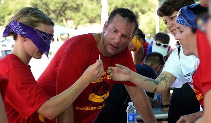 Team Undertrained & Overconfident look for the red golf tee within the white ones during the mystery event of the annual Rambler 120 Competition Sept. 19, 2015 at Joint Base San Antonio Recreation Park at Canyon Lake. The Rambler 120, which is hosted by the 502nd Force Support Squadron, features four- and eight-person teams that engage in a friendly, but hard-fought, competition that challenges participants with a 22-mile bike race, 6-mile run, 2-mile raft race and a mystery event. (U.S. Air Force photo by Edward Dixon)