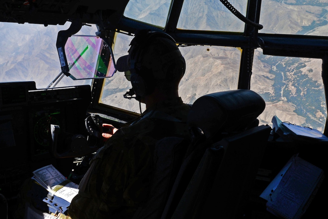 U.S. Air Force Capt. Matt Buchholtz looks out the window of his C-130J Super Hercules aircraft while flying a medical evacuation mission over Afghanistan, Sept. 4, 2015. Buchholtz is a pilot assigned to the 774th Expeditionary Airlift Squadron. 