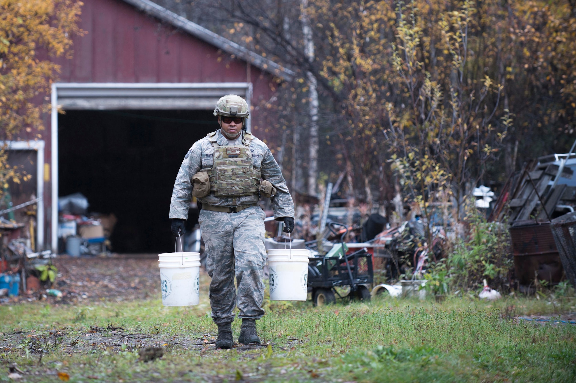 Tech. Sgt. Michael Alexander II, a 354th Civil Engineer Squadron explosive ordinance disposal technician from Eielson Air Force Base, Alaska, removes two of four buckets containing 65 sticks deteriorating dynamite from a garage in Delta Junction, Alaska, Sept. 20, 2015. The EOD flight responded to the report of explosives at the request of local authorities. (U.S. Air Force photo/Staff Sgt. Shawn Nickel)