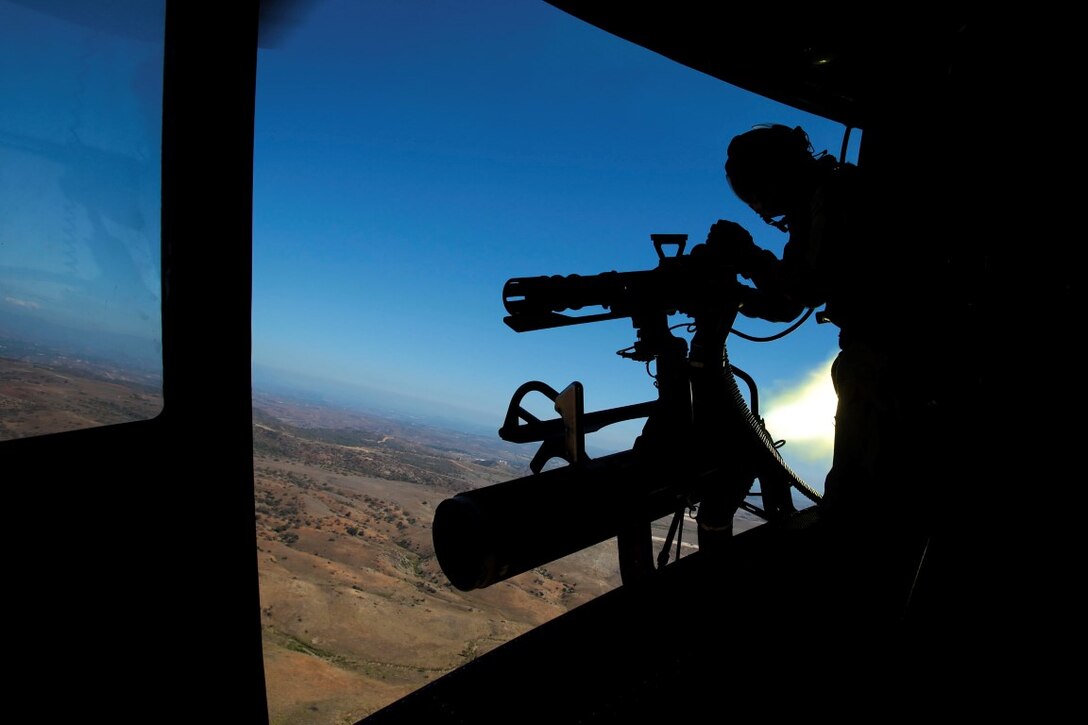 Donnelly, Idaho, native, Sgt. Elizabeth Azcuenaga, an enlisted aircrew training manager with Marine Light Attack Helicopter Squadron 169 (HMLA-169), Marine Aircraft Group 39, 3rd Marine Aircraft Wing, I Marine Expeditionary Force, fires a GAU-17 machine gun from the door of a UH-1Y Huey while the pilot simultaneously launches a rocket aboard Marine Corps Base Camp Pendleton, Calif., Sept. 17, 2015. Azcuenaga fired the weapon during a weapons proficiency range designed to help new pilots and crew chiefs become more effective with their respective weapons systems. (U.S. Marine Corps photo by Lance Cpl. Caitlin Bevel)