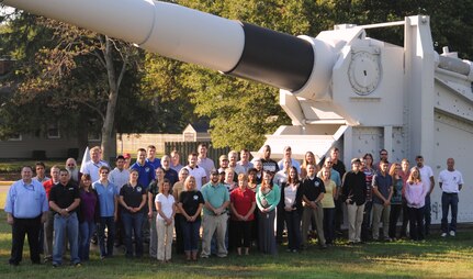 The Naval Surface Warfare Center (NSWC) Dahlgren Division Battle Management System AC-130W Stinger II team gathers in front of the static 16-inch gun on the parade field Sept. 18.  Col. Eric Forsyth, U.S. Special Operations Command (SOCOM) Program Executive Office (PEO) Fixed Wing director, recognized the team for crucial contributions to the Precision Strike Package weapon system aboard the Air Force Special Operations Command (AFSOC) AC-130W Stinger II platform at a June SOCOM ceremony. The overall AC-130W SOCOM team - including those from NSWC Crane and Dahlgren Divisions, PEO-Fixed Wing, Eglin Air Force Base, and the U.S. Special Operations Forces Support Activity - won the Program of the Year for PEO Fixed Wing. The AC-130W Stinger II primary missions are close air support and air interdiction. Close air support missions include troops in contact, convoy escort, and point air defense. Air interdiction missions are conducted against preplanned targets or targets of opportunity, including strike coordination and reconnaissance. The same team also won the Special Operations Forces Acquisition Innovator Award for integrating new warfighting capabilities into the AC-130J. The AC-130J is the Special Operations Forces next generation gunship.