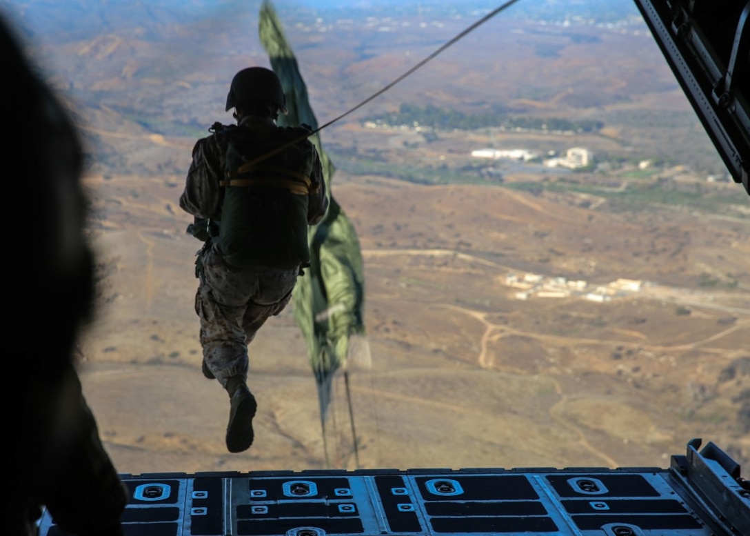 A Marine with 1st Reconnaissance Battalion, 1st Marine Division jumps out of the cargo bay of a C-130J Super Hercules aircraft during a low-level static line insertion training over Marine Corps Base Camp Pendleton, Calif., Sept. 17, 2015. The goal of the training was to sharpen a skill set that is of great advantage to expeditionary forces, allowing the jumpers to infiltrate locations where access would be too difficult for vehicles. (U.S. Marine Corps photo by Pfc. Devan Gowans/Released)
