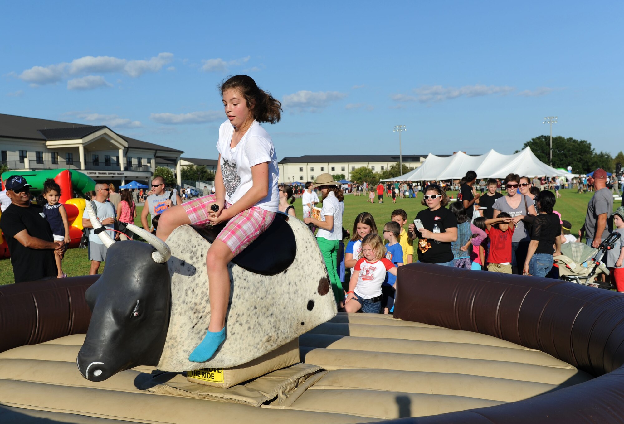 Alexia Richardson, daughter of Tech. Sgt. Casey Richardson, 602nd Training Group (Provisional) network information technology technician, rides a mechanical bull during Keesler’s Air Force birthday celebration Sept. 18, 2015, Keesler Air Force Base, Miss. The event also included music, games, contests and food to celebrate the Air Force’s 68th birthday.  (U.S. Air Force photo by Kemberly Groue)