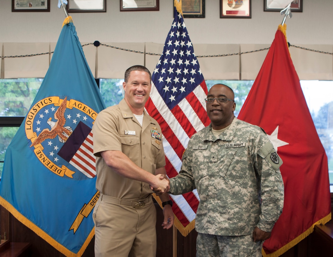 DLA Distribution commander Army Brig. Gen. Richard Dix, right, congratulates newly promoted Navy Lt. Cmdr. James McPeake.  
 
