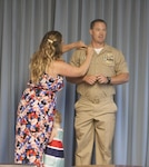 Navy Lt. James McPeake has his new rank of lieutenant commander pinned on by his wife Kelley in a ceremony on June 1.