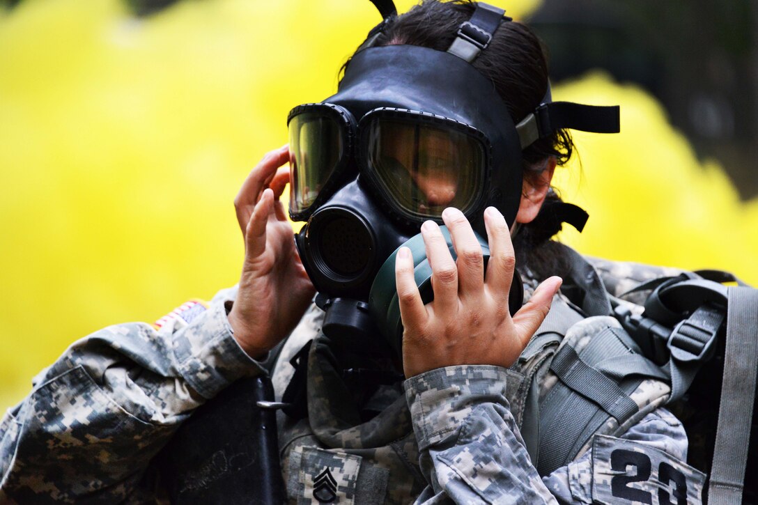 U.S. Army Staff Sgt. Elisabeth Martinez puts on a protective gas mask during the 2015 European Best Warrior Competition at the Grafenwoehr Training Area in Germany, Sept. 14, 2015. Martinez is assigned to Company B, Landstuhl Regional Medical Center. U.S. Army photo by Gertrud Zach