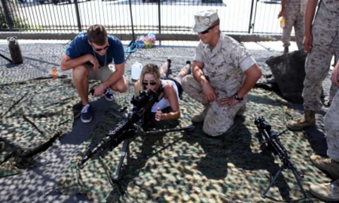 Lance Cpl. Matthew Ritter, a heavy equipment operator with Bulk Fuel Company, 7th Engineer Support Battalion, shows a couple a weapons system during San Diego Fleet Week 2015 aboard Naval Base Coronado, Calif., Sept. 20, 2015. Thirty-seven Marines from 7th ESB presented static displays during the event to demonstrate the quality of military assets to the citizens of San Diego. 