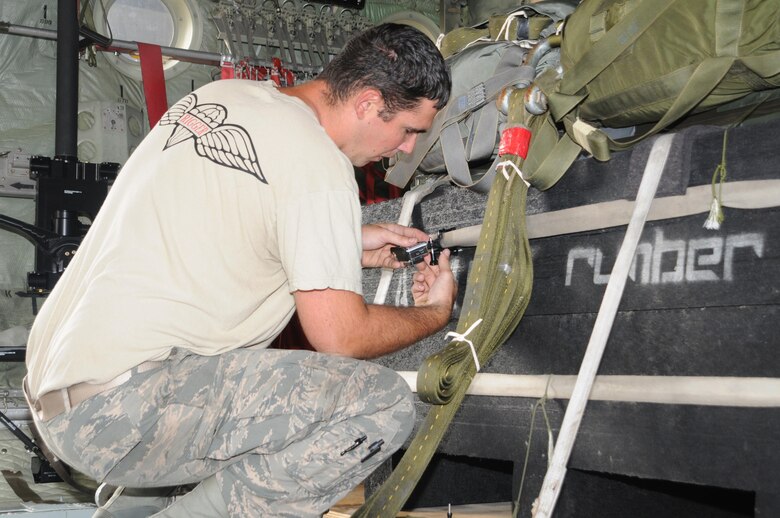 Tech. Sgt. Anthony Cresanto, an air transportation specialist with the 76th Aerial Port Squadron, attaches a video camera to a pallet aboard a C-130H Hercules aircraft here, August 27, 2015. Cresanto installed five cameras to record the cargo drop from multiple angles. The drop was part of a nine C-130 aircraft formation training flight during the C-130 Round-Up. The Round-Up is a competition among airlift squadrons and aerial port squadrons which tests the capabilities of their airmen. (U. S. Air Force photo/ Tech. Sgt. Rick Lisum)