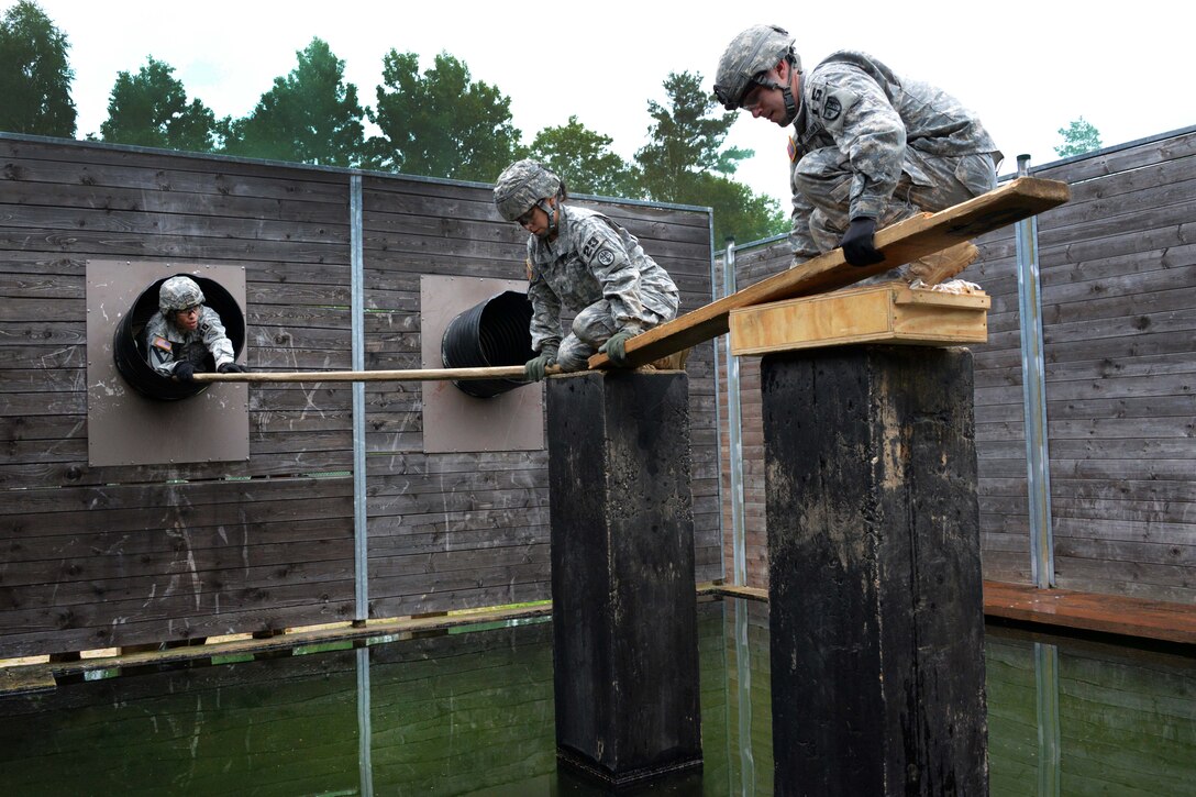 U.S. soldiers lay boards over a water obstacle during the 2015 European Best Warrior Competition at the Grafenwoehr Training Area in Germany, Sept. 14, 2015. Some 22 candidates are participating in the annual weeklong competition, the most prestigious competitive event of its kind in the region. The soldiers are assigned to U.S. Army Europe. U.S. Army photo by Gertrud Zach