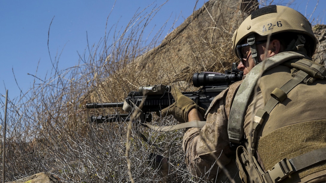 A Marine with Company A, 1st Reconnaissance Battalion, 1st Marine Division, fires behind cover at simulated targets during immediate action drills aboard Marine Corps Base Camp Pendleton, Calif., Sept. 9, 2015. The drills were part of a 2-week training schedule used to build on basic infantry skills for an upcoming deployment with a Marine Expeditionary Unit. (U.S. Marine Corps photo by Cpl. Tony Simmons/RELEASED)