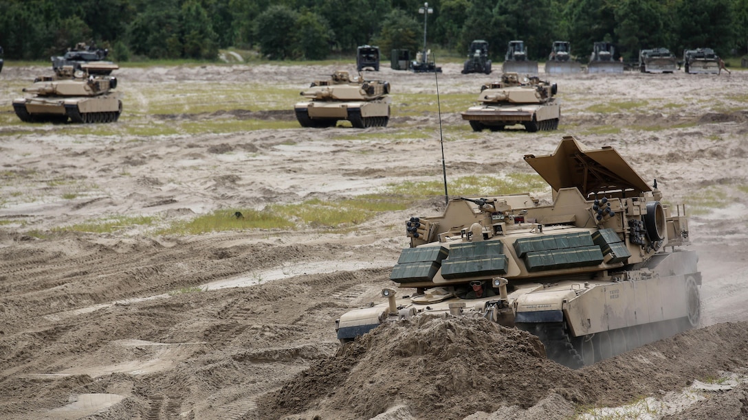 Marines with Mobile Assault Company, 2nd Combat Engineer Battalion, plow dirt in an M1 Assault Breacher Vehicle during a vehicle breaching exercise aboard Engineer Training Area 2, Camp Lejeune, N.C., Sept. 17, 2015. While tanks provided cover, the ABV filled in a ditch as the first step to breaching the berm for the tanks to pass through. 