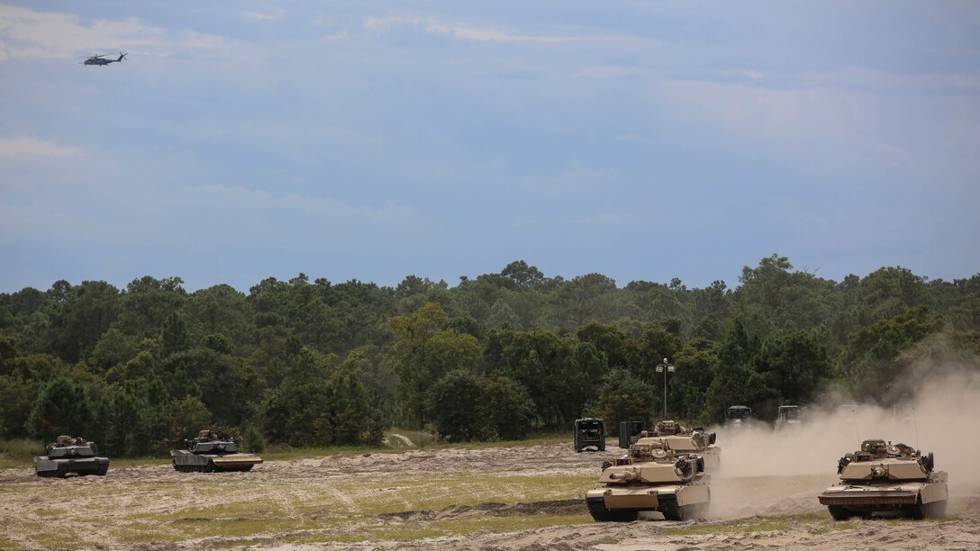 Marines with Alpha Company, 2nd Tank Battalion, use M1 Abrams tanks to provide cover for an M1 Assault Breacher Vehicle during a vehicle breaching exercise aboard Engineer Training Area 2, Camp Lejeune, N.C., Sept. 17, 2015. While the tanks provided cover, the ABV filled in a ditch as the first step to breaching the berm for the tanks to pass through. 