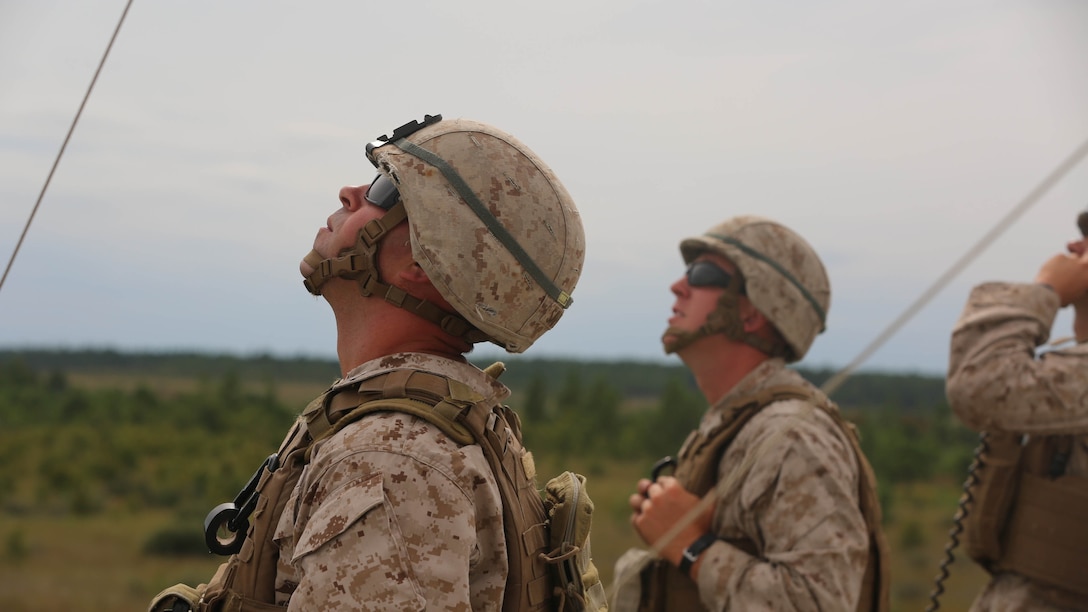 After calling in air support during artillery fire support training, Marines with 1st battalion, 8th Marine Regiment, watch to make sure the suppression hits its target on Camp Lejeune, N.C., Sept. 17, 2015. Smoke or illuminators are used to make it easier for air support to see their intended target. 