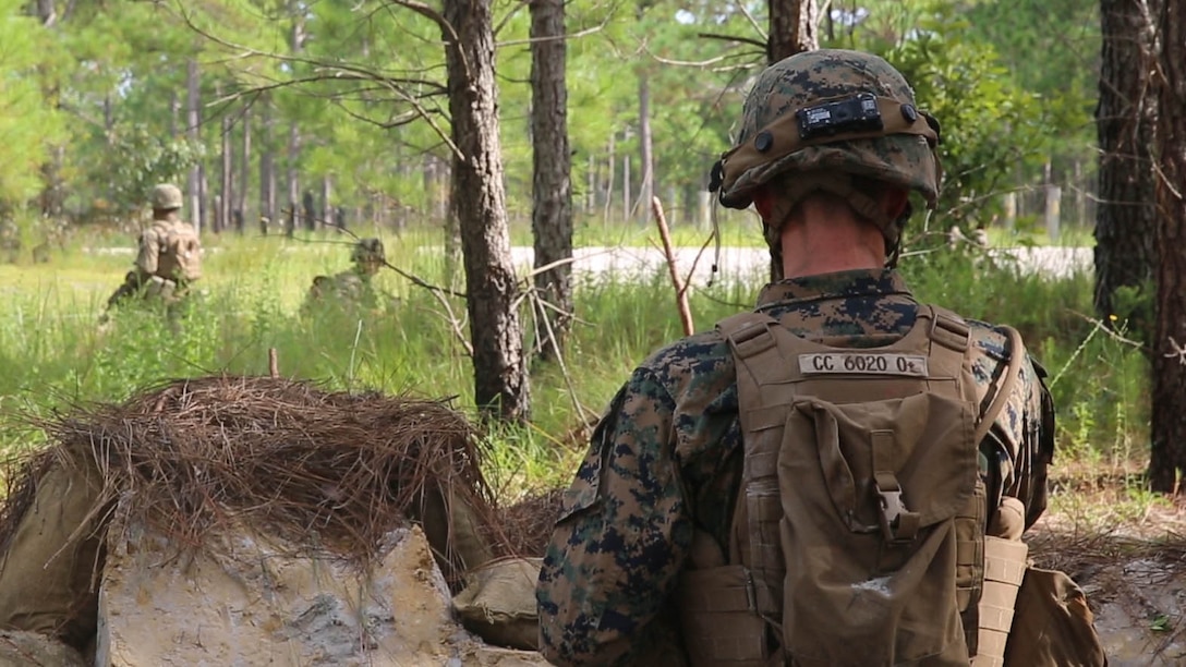 Lance Cpl. Cody Conlon, a fireteam leader with 2nd Marine Regiment, watches Marines with his unit set up defenses from his fighting position during a battalion deployment for training exercise aboard Camp Lejeune, N.C., Sept. 16, 2015. The defensive training took place during a nine-day deployment for training exercise designed to prepare for a variety of combat scenarios, including defensive, offensive, and urban operations.