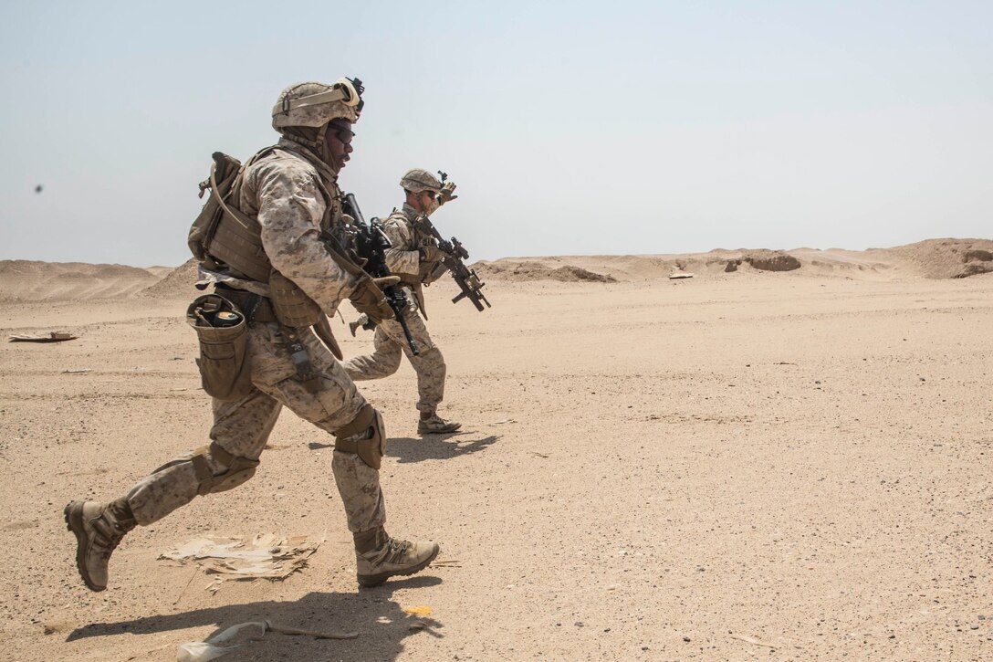 KUWAIT (Aug. 28, 2015) U.S. Marines with Kilo Company, Battalion Landing Team, 3rd Battalion, 1st Marine Regiment, 15th Marine Expeditionary Unit, respond to simulated contact in an urban environment. During the training, Marines learned how to incorporate an M1A1 Abrams tank in squad attacks in an urban environment. Elements of the 15th MEU are ashore in Kuwait for sustainment training to maintain and enhance the skills they developed during their pre-deployment training period.  The 15th MEU is embarked aboard the Essex Amphibious Ready Group and deployed to maintain regional security in the U.S. 5th Fleet area of operations. (U.S. Marine Corps photo by Sgt. Emmanuel Ramos/Released)