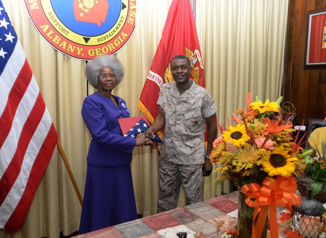 Col. James C. Carroll III, commanding officer, Marine Corps Logistics Base Albany, presents Annette Williams, financial management analyst, Accounting Branch, MCLB Albany, with an American flag, which flew over Coffman Hall on her behalf as well as other certificates honoring her 29 years of service to both MCLB Albany and Marine Corps Logistics Command. The ceremony was held in the Carson Conference Room, Building 3500, Sept. 22. Kent Morrison, executive director, assisted with the presentation.
