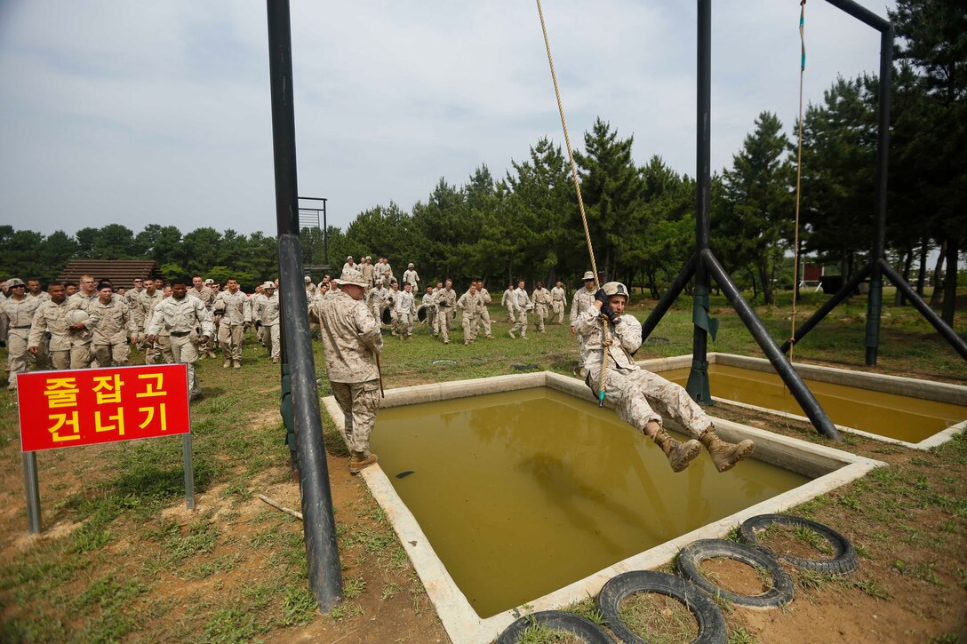 U.S. Marines Corps Capt. Stuart Scheller, the Weapons Company Commander, 2d Battalion, 3d Marines, demonstrates how to properly execute an obstacle on a Republic of Korea Marine Corps obstacle course during Korean Marine Exchange Program 15-19 (KMEP) on Camp Mujuk, Republic of Korea, June 22, 2015. KMEP 15-19 provided an opportunity to train the units’ complex Company and Battalion level collective tasks on dynamic, combined-arms ranges. (U.S. Marine Corps photo by MCIPAC Combat Camera Lance Cpl. Colby Cooper/Released)           