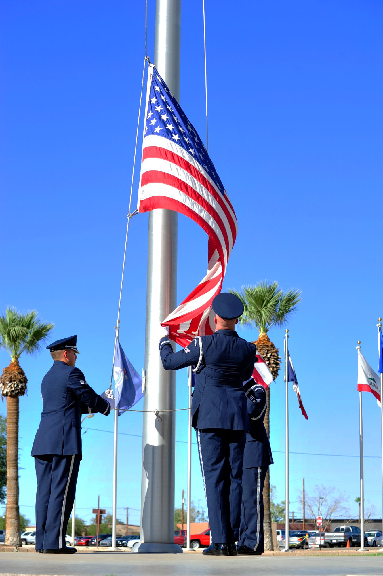 Luke Air Force Base Honor Guard members lower the American flag as part of the POW/MIA Recognition Day Retreat ceremony Sept. 18, 2015 near the wing headquarters building at Luke Air Force Base, Ariz. (U.S. Air Force photo by Senior Airman Grace Lee)