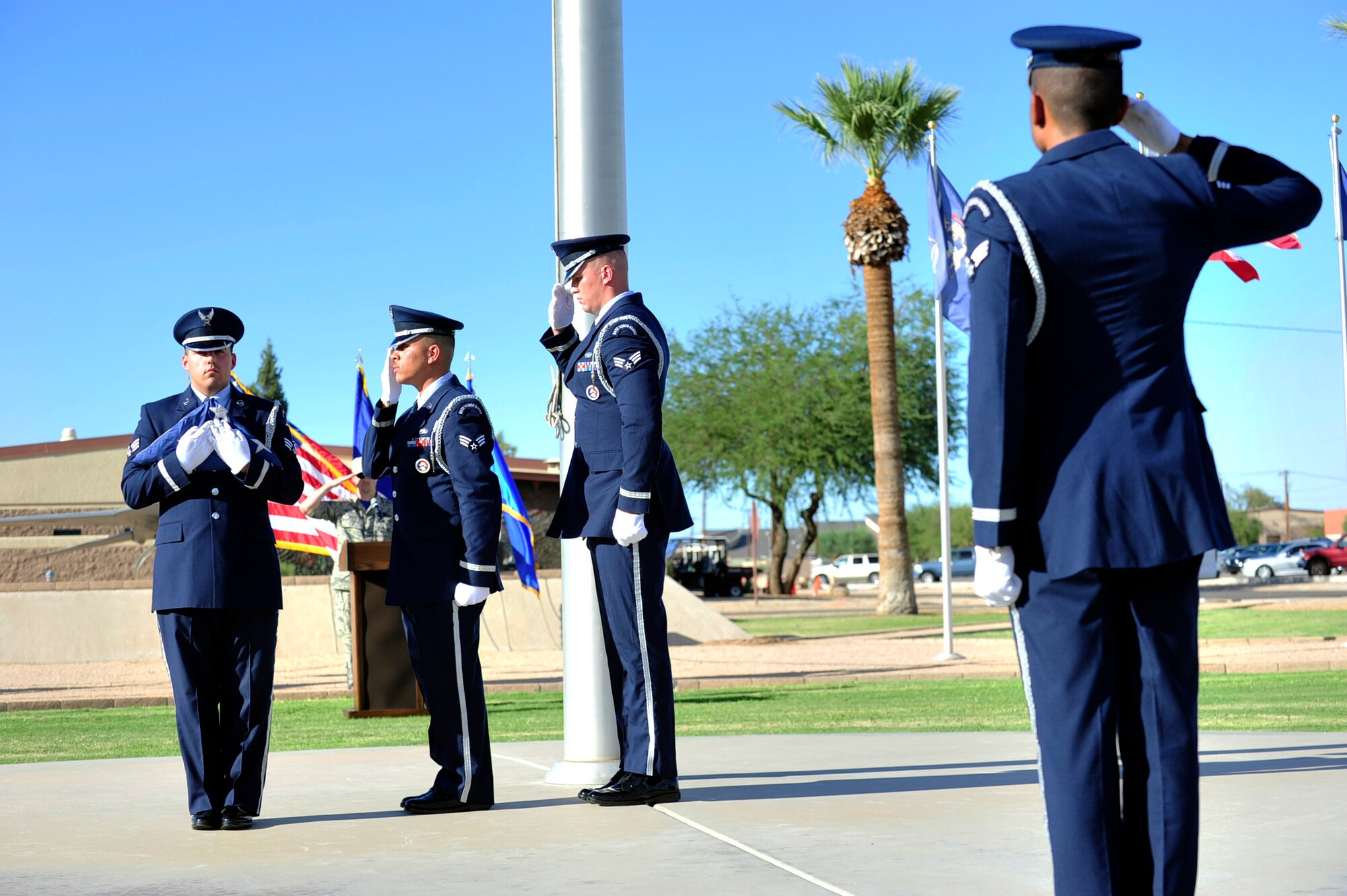 Luke Air Force Base Honor Guard members salute after folding the flag as part of the POW/MIA Recognition Day Retreat ceremony Sept. 18, 2015 near the wing headquarters building at Luke Air Force Base, Ariz. (U.S. Air Force photo by Senior Airman Grace Lee)