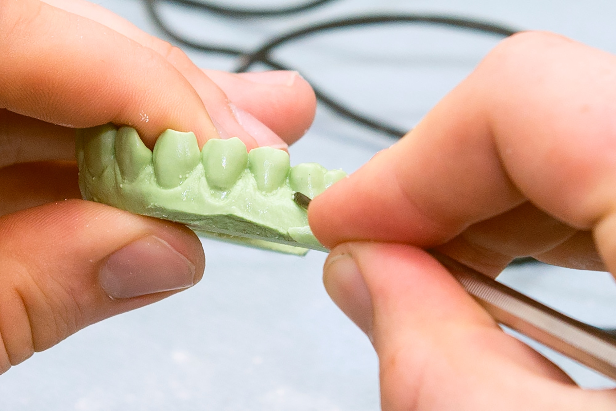 A dental lab technician from the 23d Aerospace Medicine Squadron removes defects from a tooth mold Sept. 21, 2015, at Moody Air Force Base, Ga. Dental lab technicians are responsible for making dental hardware such as crowns, night guards and dentures for patients. (U.S. Air Force photo by Airman 1st Class Greg Nash/Released)
