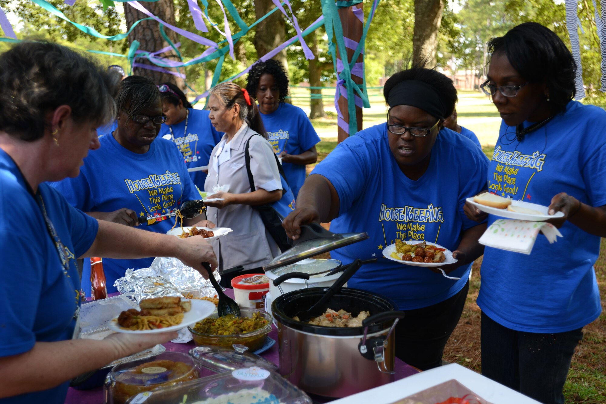 Custodial workers assigned to the 20th Force Support Squadron partake in a barbeque and pot luck as they wrap up International Housekeeping Week at Shaw Air Force Base, S.C., Sept. 18, 2015. After a week of games to boost morale and teamwork, prizes were given to the winners and food was shared by all. (U.S. Air Force photo by Airman 1st Class Kelsey Tucker/Released)