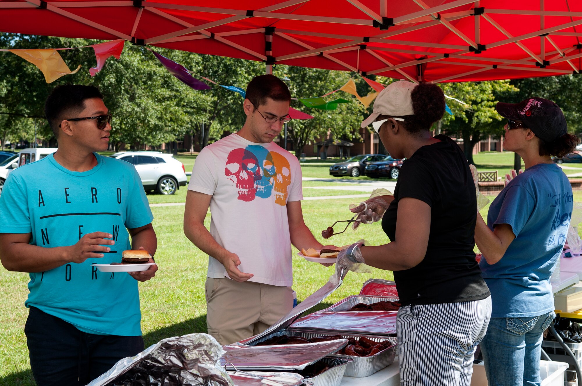 Dorm Airmen receive food from volunteers during a dorm dwellers barbecue event, Sept. 19, 2015, at Seymour Johnson Air Force Base, North Carolina. More than 110 Airmen from the dorms came out and enjoyed free food and fellowship provided by the 4th Fighter Wing Chaplain Corps’ Protestant Men of the Chapel. (U.S. Air Force photo/Airman 1st Class Shawna L. Keyes)